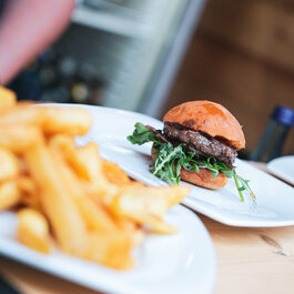 Ein weißer Flurbereich mit einer offenen Garderobe, Kissen und einem kleinen schwarzen Schild