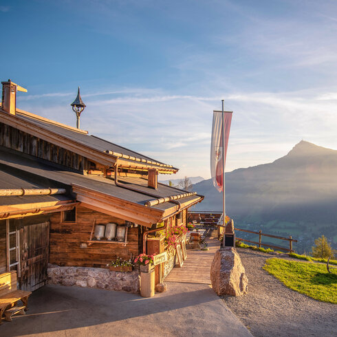 Ein weißer Flurbereich mit einer offenen Garderobe, Kissen und einem kleinen schwarzen Schild