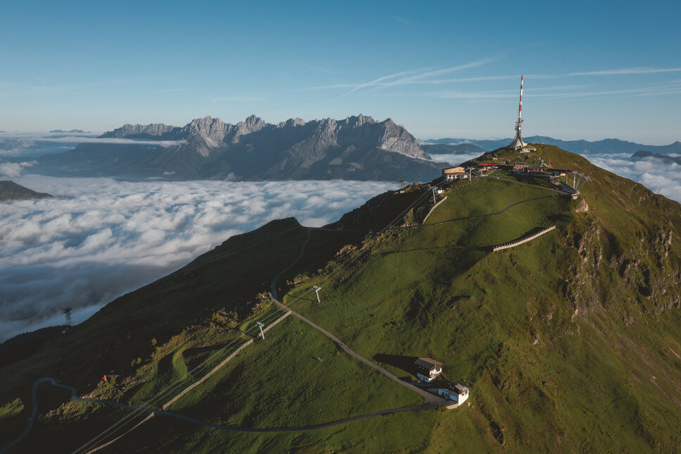 Ein weißer Flurbereich mit einer offenen Garderobe, Kissen und einem kleinen schwarzen Schild