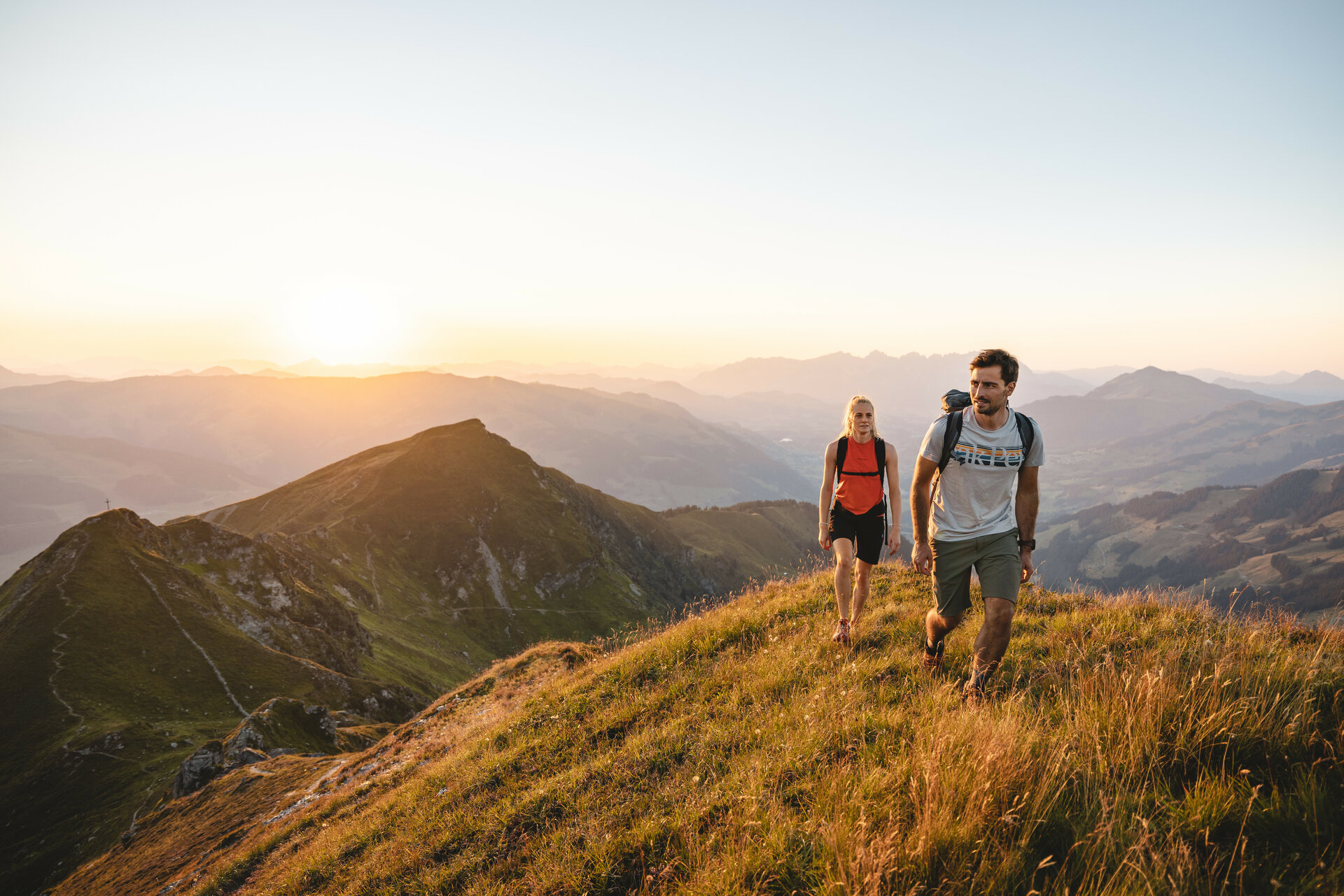 Zwei Menschen wandern bei Sonnenaufgang