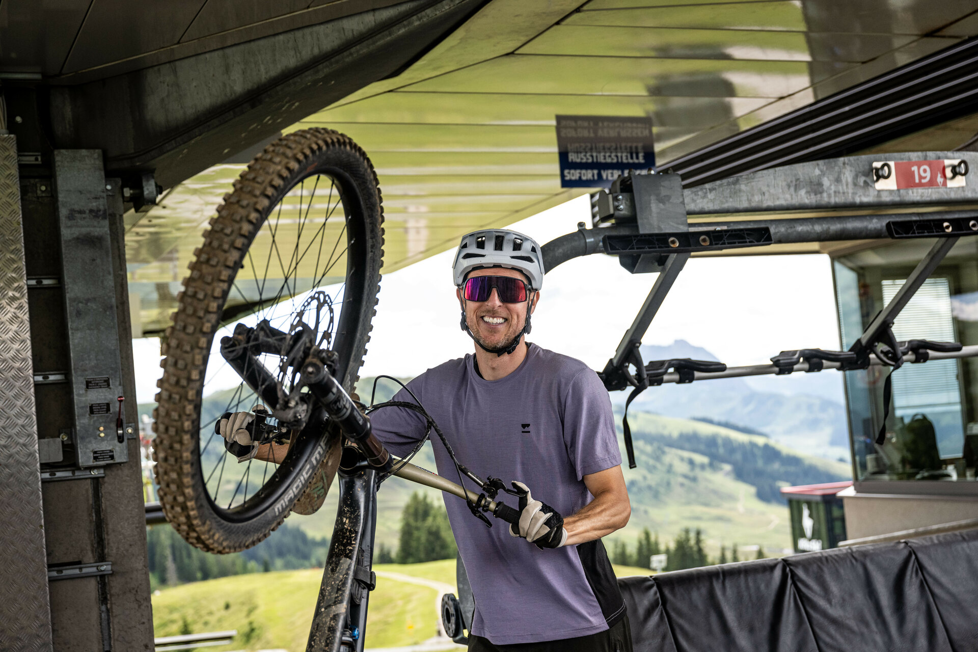 Ein weißer Flurbereich mit einer offenen Garderobe, Kissen und einem kleinen schwarzen Schild