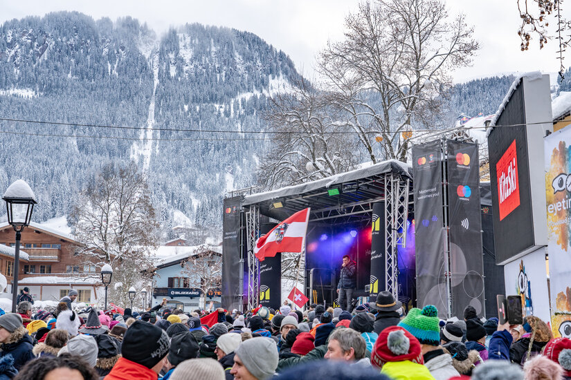 Ein weißer Flurbereich mit einer offenen Garderobe, Kissen und einem kleinen schwarzen Schild