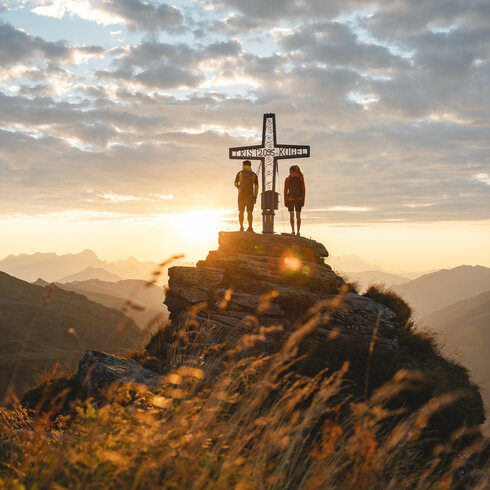 Ein weißer Flurbereich mit einer offenen Garderobe, Kissen und einem kleinen schwarzen Schild