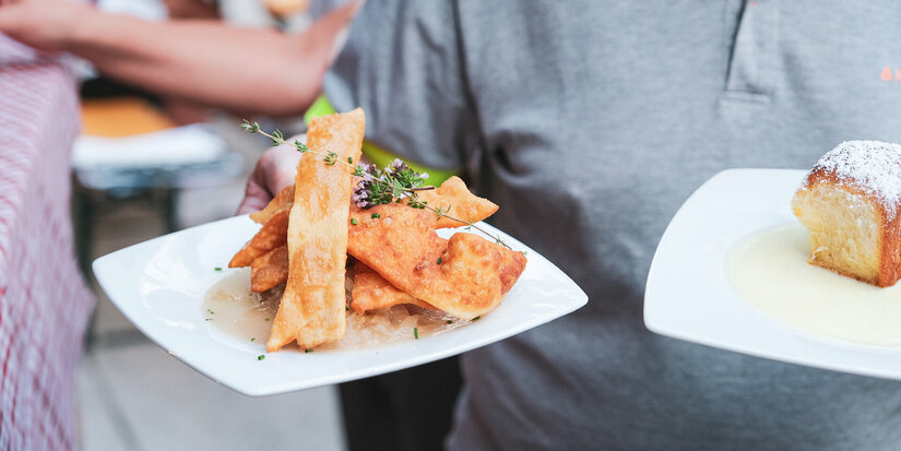 Ein weißer Flurbereich mit einer offenen Garderobe, Kissen und einem kleinen schwarzen Schild