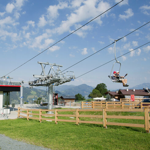 Ein weißer Flurbereich mit einer offenen Garderobe, Kissen und einem kleinen schwarzen Schild