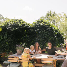 Ein weißer Flurbereich mit einer offenen Garderobe, Kissen und einem kleinen schwarzen Schild