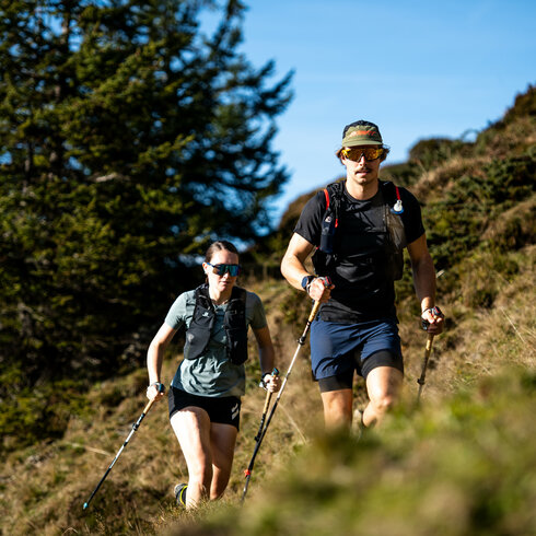 Ein weißer Flurbereich mit einer offenen Garderobe, Kissen und einem kleinen schwarzen Schild
