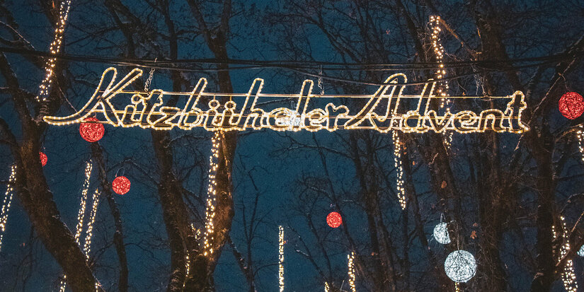 Ein weißer Flurbereich mit einer offenen Garderobe, Kissen und einem kleinen schwarzen Schild