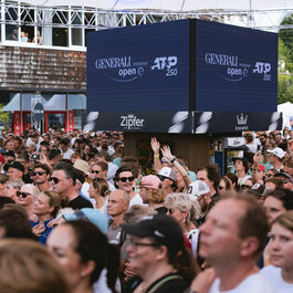 Ein weißer Flurbereich mit einer offenen Garderobe, Kissen und einem kleinen schwarzen Schild