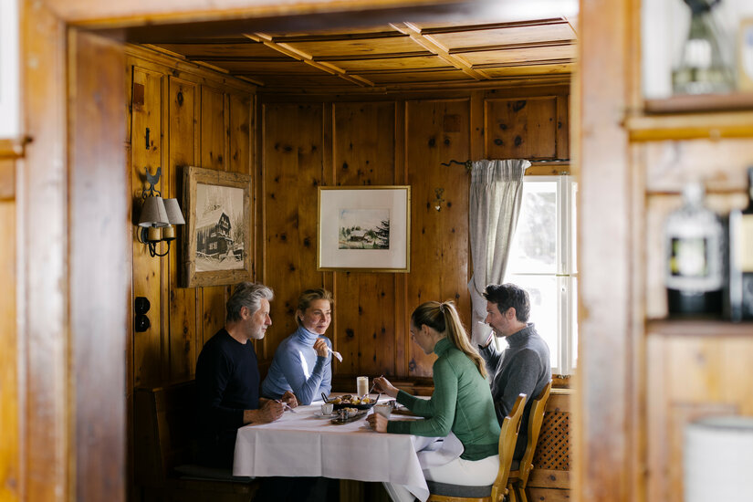 Ein weißer Flurbereich mit einer offenen Garderobe, Kissen und einem kleinen schwarzen Schild