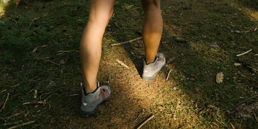 Ein weißer Flurbereich mit einer offenen Garderobe, Kissen und einem kleinen schwarzen Schild