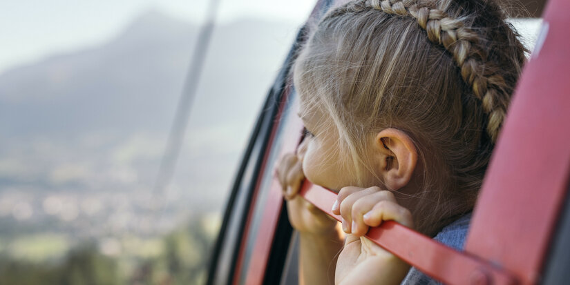 Ein weißer Flurbereich mit einer offenen Garderobe, Kissen und einem kleinen schwarzen Schild