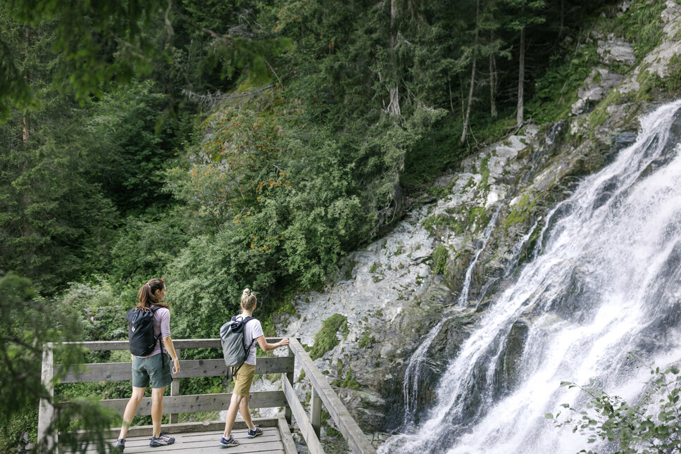 Zwei Personen schauen auf den Sintersbacher Wasserfall