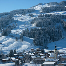 Jochberg Dorf mit die Skipisten und Lifte im Hintergrund