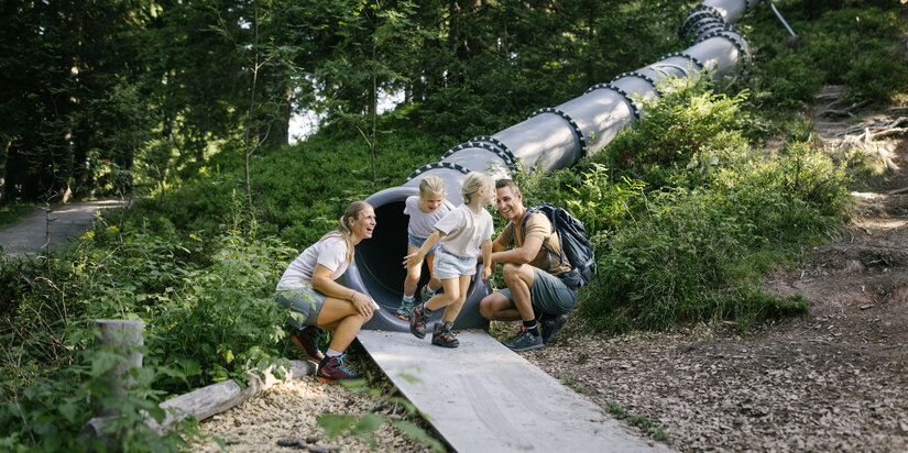 Ein weißer Flurbereich mit einer offenen Garderobe, Kissen und einem kleinen schwarzen Schild