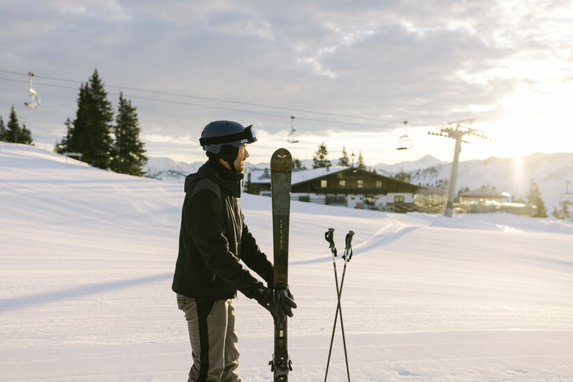 Ein weißer Flurbereich mit einer offenen Garderobe, Kissen und einem kleinen schwarzen Schild