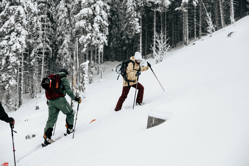 2 Skitourengeher mit ein Wald im Hintergrund