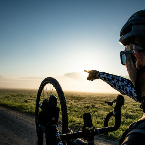 Ein weißer Flurbereich mit einer offenen Garderobe, Kissen und einem kleinen schwarzen Schild