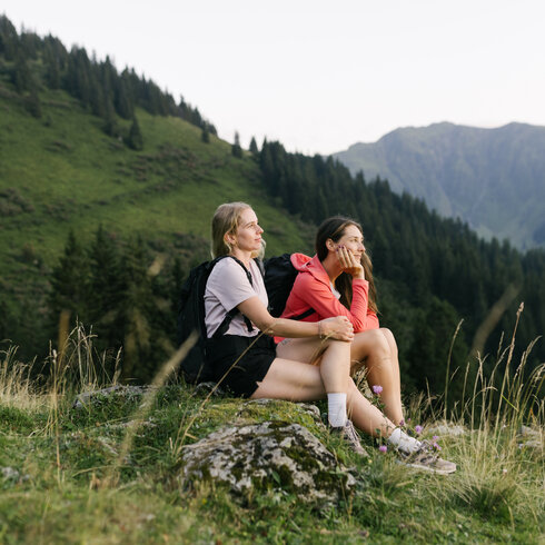 Ein weißer Flurbereich mit einer offenen Garderobe, Kissen und einem kleinen schwarzen Schild