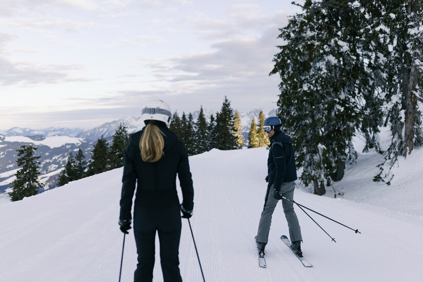 Ein weißer Flurbereich mit einer offenen Garderobe, Kissen und einem kleinen schwarzen Schild