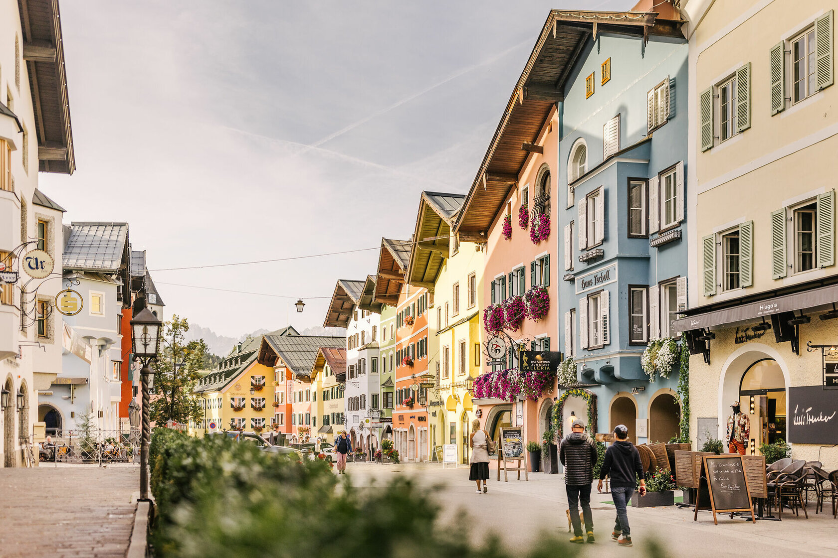 Stadtaufnahmen Innenstadt Herbst Kitzbühel (c) Kitzbühel Tourismus (16) Ein weißer Flurbereich mit einer offenen Garderobe, Kissen und einem kleinen schwarzen Schild