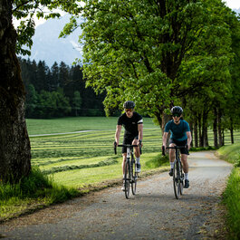 Ein weißer Flurbereich mit einer offenen Garderobe, Kissen und einem kleinen schwarzen Schild