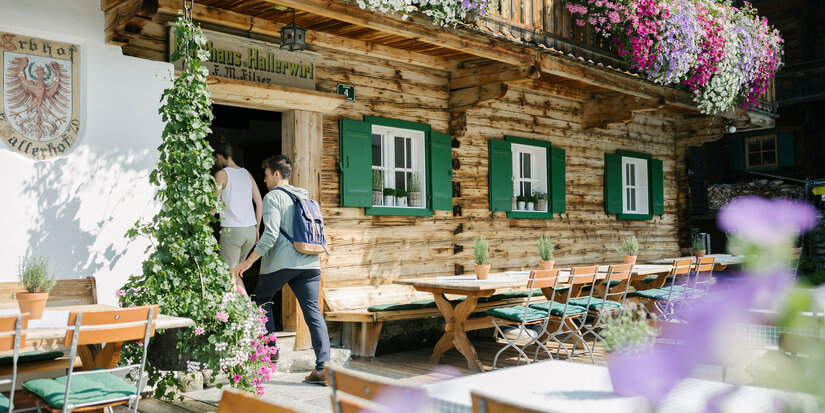 Ein weißer Flurbereich mit einer offenen Garderobe, Kissen und einem kleinen schwarzen Schild
