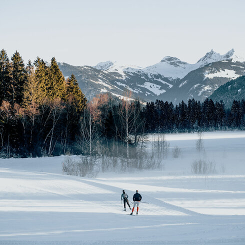 Ein weißer Flurbereich mit einer offenen Garderobe, Kissen und einem kleinen schwarzen Schild