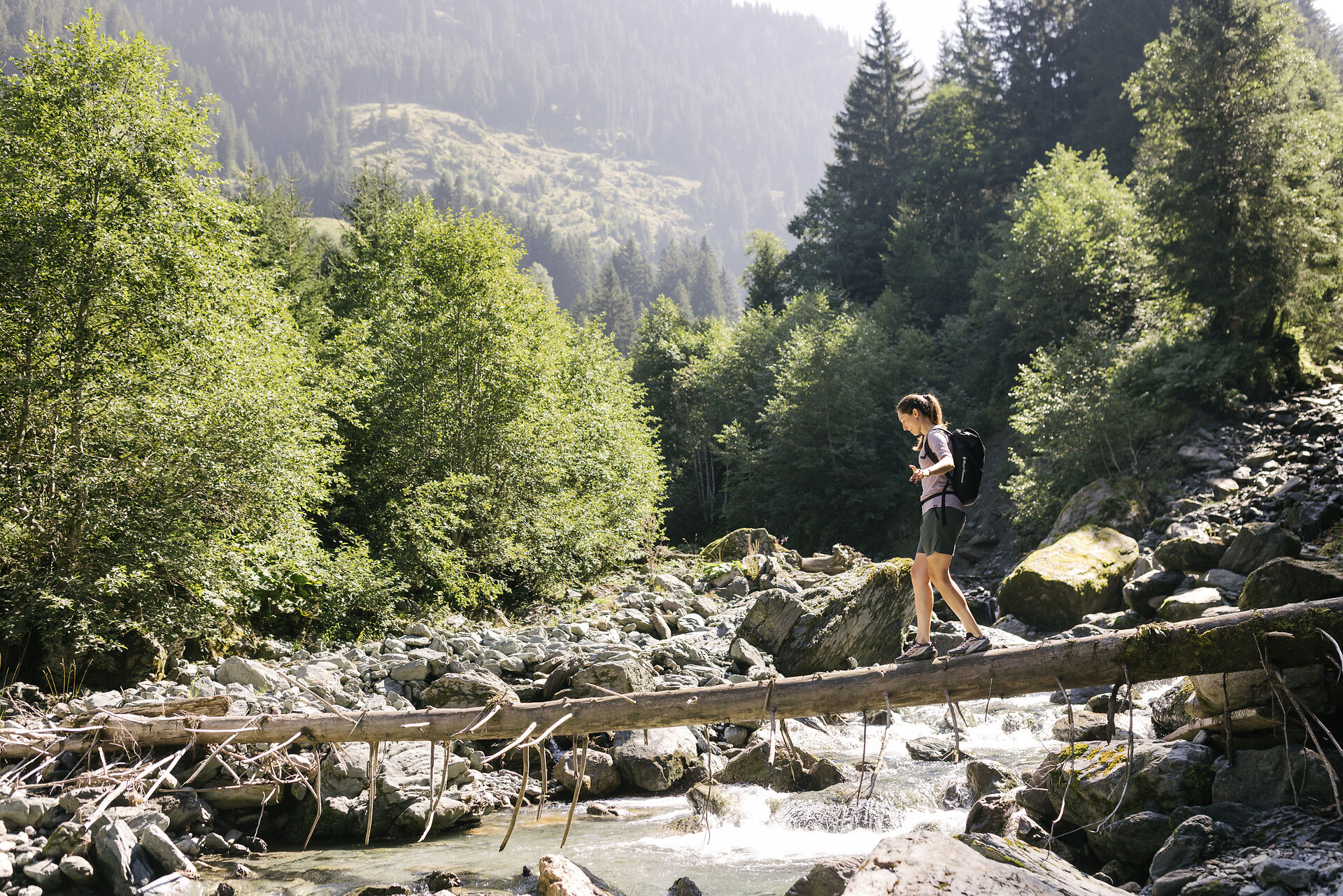 Person, die über einen Baumstamm läuft